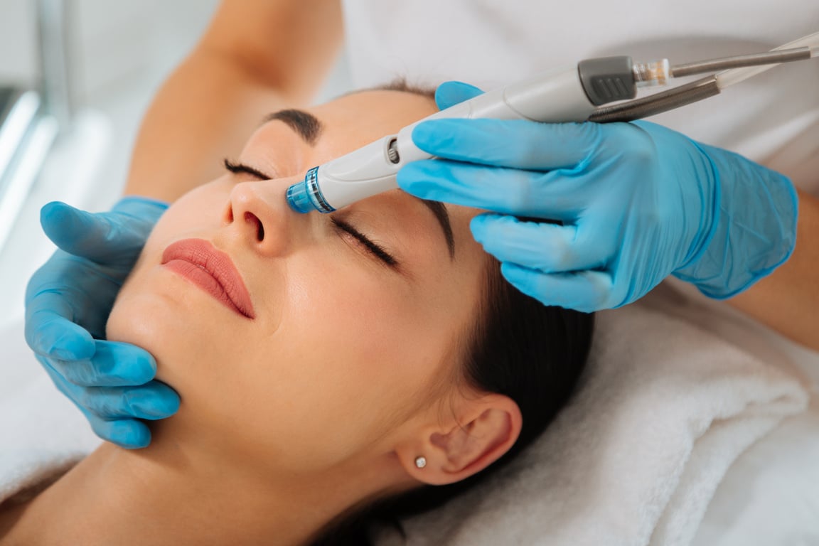 Delighted nice positive woman having hydrafacial procedure